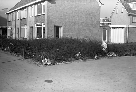 811238 Afbeelding van zwerfafval tussen de struiken ter hoogte van de huizen Jan van Galenstraat 73-77 te Utrecht.